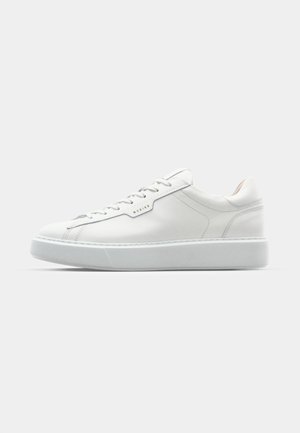 Baskets en cuir blanc avec un bout arrondi, un laçage plat et une semelle en caoutchouc grise. Caractérisées par des coutures discrètes et un accent de logo.