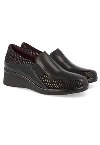 Zapatos negros tipo slip-on con una parte superior de patrón texturizado negro, que presenta una puntera de cuero liso y una suela en cuña. Forrados en burdeos.