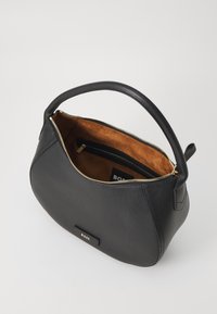 Zwarte leren handtas met een ronde vorm, beige suède interieur, gouden rits en een subtiele logo-accent op de buitenkant.