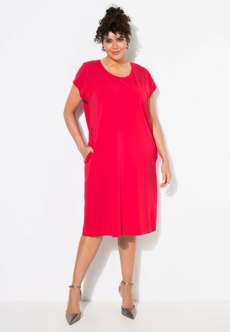 Vestito rosso a maniche corte con scollo rotondo, tasche laterali e dettaglio di foglia ricamato sulla spalla. Tessuto liscio e lunghezza al ginocchio.