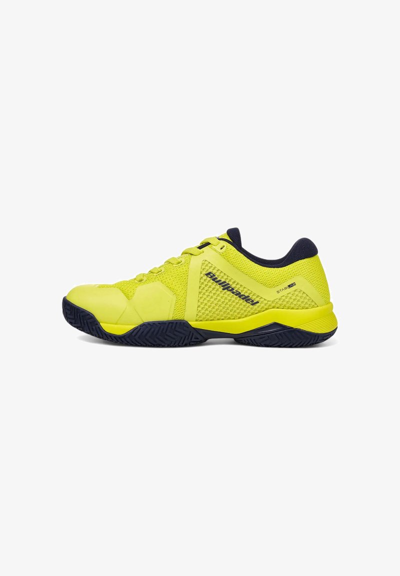 Zapatilla deportiva verde lima con un upper de malla texturizada, acentos en azul marino y una suela de goma con un patrón de espiga para mayor tracción.