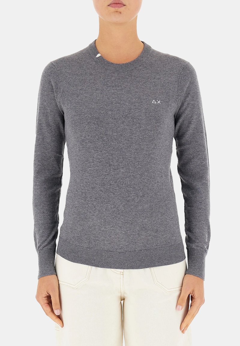 Maglione grigio a maglia con maniche lunghe, scollo e orlo a costine, caratterizzato da un piccolo logo bianco sul lato sinistro del petto. Texture liscia, design aderente.