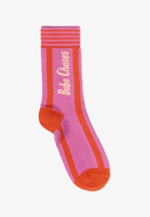 Roze sok met oranje hiel, teen en strepen, met de tekst "Bobo Choses" in crème langs de zijkant.