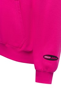 Felpa fucsia con polsini e fondo a costine, dotata di tasca. La manica sinistra presenta un'etichetta nera con la scritta "Most Alive" in testo bianco.