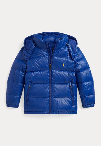 Zils puffers jackets ar rāvējslēdzēju priekšpusē, noņemamu kapuci un pogu akcentiem. Iespējotas divas sānu rāvējslēdzēja kabatas un izšūta tekstūra.