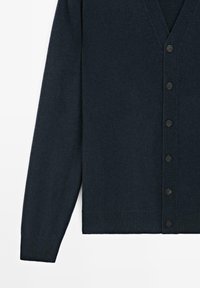 Tmavě námořnický kardigan s výstřihem do V, dlouhými rukávy a šesti černými knoflíky uprostřed, vyrobený z měkké, strukturované tkaniny.