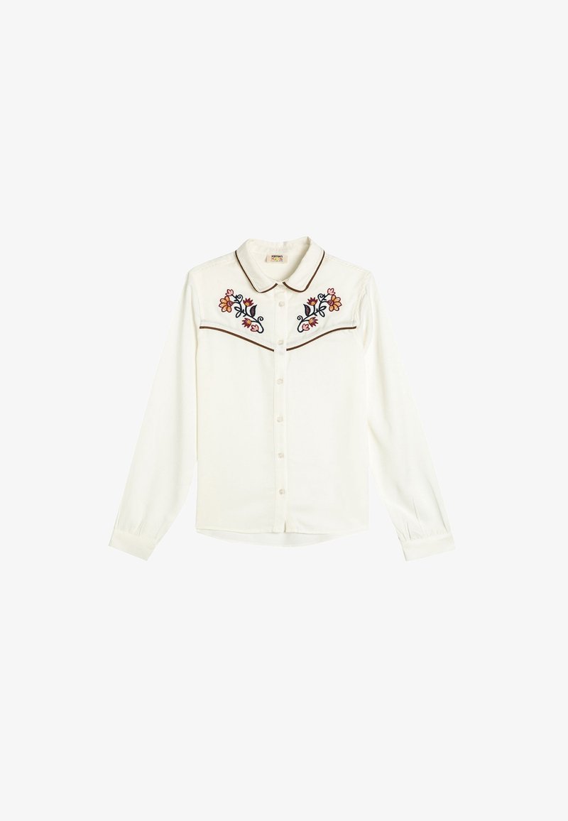 Chemise blanche à manches longues avec boutons, col pointu, bordure marron et broderie florale symétrique sur les panneaux de poitrine.