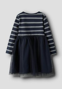 Granatowa sukienka z białymi pasekami na górze i warstwową spódnicą z granatowego tiulu. Długie rękawy, okrągły dekolt i teksturowany materiał.