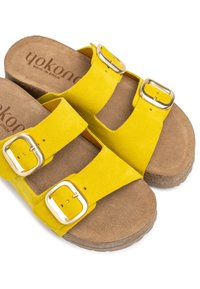 Sandales en daim jaunes avec deux sangles ajustables et boucles dorées. Semelle intérieure rembourrée couleur tan avec une semelle texturée pour une meilleure adhérence.
