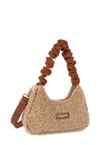 Sac à main en fausse fourrure beige de forme arrondie, avec une poignée en matériau doux brun froncé et des détails en métal doré.