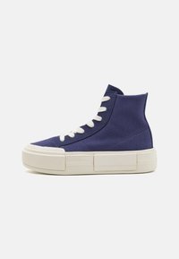 High-top sneakers in navy canvas with white laces, featuring a textured surface and a chunky cream rubber sole with distinct horizontal accents.
