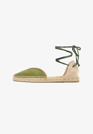 Espadrille verte à bout fermé avec une semelle en jute tressé et un dos beige, dotée de liens verts à nouer autour de la cheville.