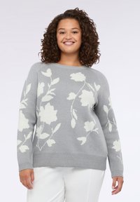 Šedý pletený svetr s bílým květinovým vzorem, kulatým výstřihem, dlouhými rukávy a vroubkovaným lemem. Měkká textura a uvolněný střih.