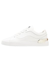 White leather sneakers with textured accents, a smooth finish, and a decorative silver hardware detail on the side.
