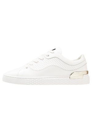 Zapatillas de cuero blancas con acentos texturizados, un acabado suave y un detalle decorativo de hardware plateado en el costado.