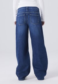 Pantalones vaqueros de pierna ancha de mezclilla, con cintura alta, dos bolsillos traseros y costuras en contraste en las costuras.