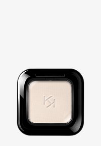 Ombre à paupières beige compacte carrée avec le logo "KM" en relief, encastrée dans un emballage en plastique noir brillant sur fond blanc.