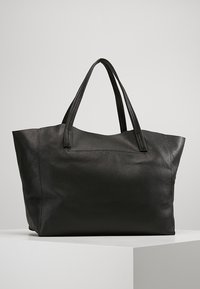 Svart läder tote-väska med en texturerad yta, dubbla plana handtag och öppen topp. Har en rymlig insida och strukturerad form.