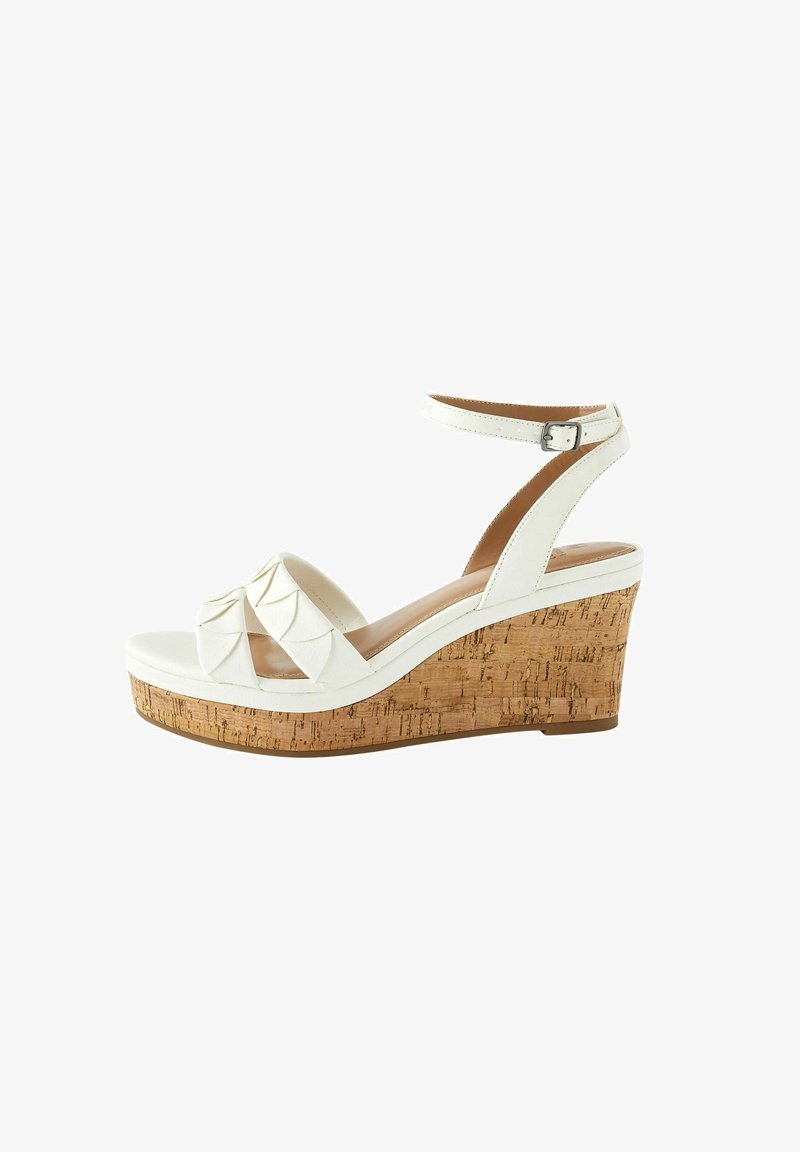 White wedge sandal with cork heel, featuring a textured, layered strap design and adjustable ankle strap. Smooth surface and sturdy base.