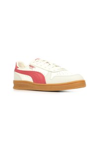 Sneaker bianca con logo Puma rosa e striscia laterale, dotata di suola in gomma beige, punta arrotondata e dettagli perforati per la traspirabilità.