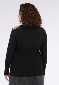 Maglione nero lavorato a maglia con texture a coste, con spalle a taglio e maniche lunghe, adatto per un abbigliamento casual.