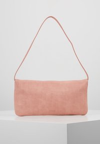 Jasnoróżowa torba na ramię wykonana z teksturowanej tkaniny, o wydłużonym kształcie i wąskim pasku do noszenia. Prosty logo marki z przodu.