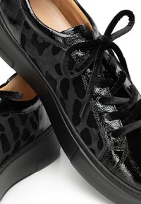 Sneakers neri con una finitura lucida in pelle verniciata e una texture in suede, con un motivo leopardato, punta rotonda e suola in gomma piatta.