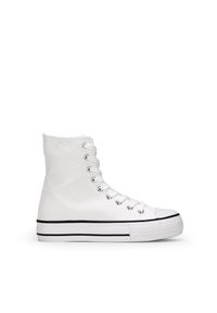 Zapatilla alta de lona blanca con puntera de goma, ojales plateados y una franja negra en contraste en la suela. Textura suave, diseño clásico.