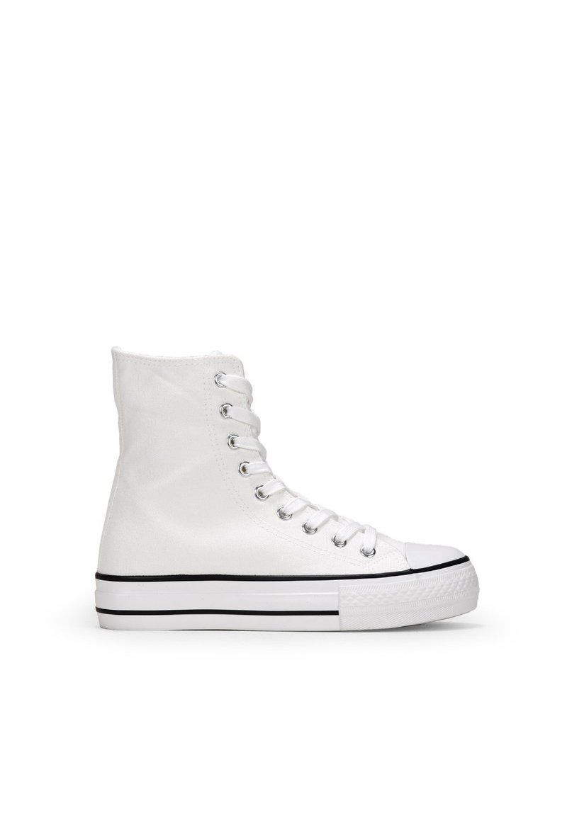 Zapatilla alta de lona blanca con puntera de goma, ojales plateados y una franja negra en contraste en la suela. Textura suave, diseño clásico.