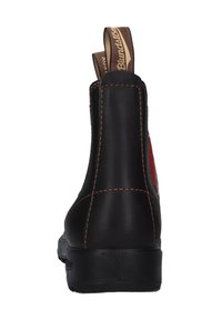Stivale alla caviglia in pelle nera con punta arrotondata, cuciture a contrasto e una linguetta sul retro. Presenta un accento rosso su un lato.