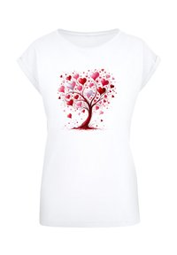 White t-shirt featuring a colorful design of a heart-shaped tree with red and pink hearts, detailed branches, and a rounded neckline.