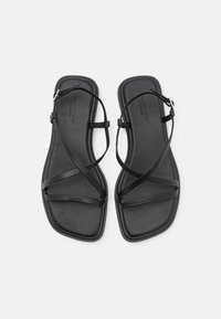 Zwarte platte sandalen met een minimalistisch ontwerp en kruislings gespen, vierkante teen en een gladde textuur. Verstelbare enkelgesp.