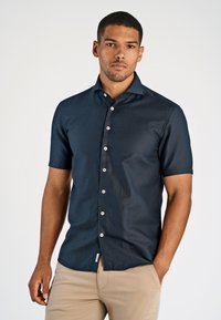 Marineblauwe overhemd met korte mouwen van lichtgewicht stof, met een knoopsluiting aan de voorkant met witte knopen en een eenvoudige kraag, gladde textuur.