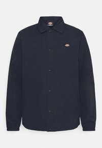 Black button-up jacket with collar, elastic cuffs, two side pockets, and small multicolor logo on the left chest.