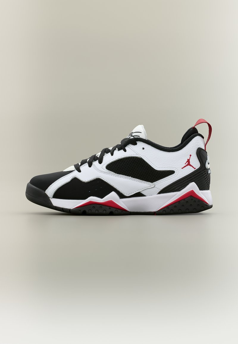 Zapatilla baja en negro, blanco y rojo con paneles de malla, cierre de cordones y logo Jumpman en el lateral y en la lengüeta del talón.