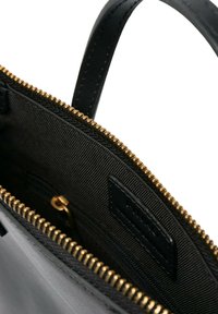 Borsa nera con esterno in pelle liscia, zip dorata e interno in tessuto texturizzato. Presenta un'etichetta piatta e manico in pelle.