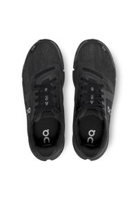 Czarne buty biegowe z teksturowaną górą z tkaniny, z amortyzowaną podeszwą, płaskimi sznurowadłami oraz logo na boku i wkładce.