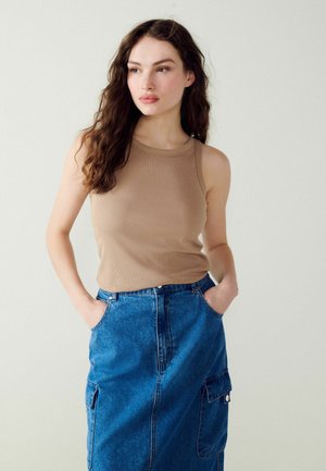 Tan geribbelde tanktop met een ronde hals, gecombineerd met een spijkerrok met voorzakken en een lichte A-lijn vorm.