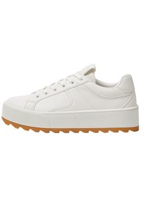 Baskets en cuir blanc avec une semelle en caoutchouc plate et texturée et un motif en zigzag. Elles présentent des accents cousus et un système de laçage circulaire.