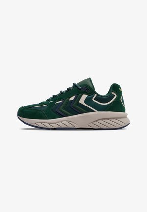 Green sneaker with suede and mesh materials. Features zigzag design in darker green, beige sole, and textured accents along the upper.