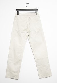 Beige bomullbyxor med rak bendesign, med två bakfickor och midjeband. Visas på en svart galge mot en vit bakgrund.