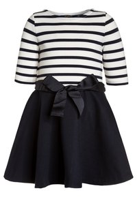 Vestido de niña con parte superior a rayas horizontales blancas y negras, mangas tres cuartos, falda negra y cinturón de moño negro en la cintura.