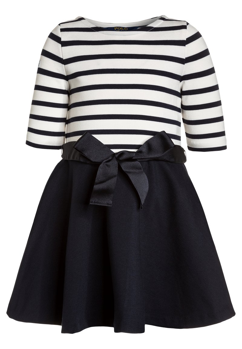 Vestido de niña con parte superior a rayas horizontales blancas y negras, mangas tres cuartos, falda negra y cinturón de moño negro en la cintura.