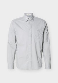 Chemise gris clair à manches longues, boutonnée, avec col boutonné et poche poitrine ornée d'un petit logo brodé.