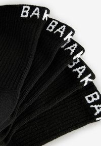 Mustad mustrid musta kangaga, ribidega disain ja valge "BAK" kiri varrel, paigutatud tuulelippu.