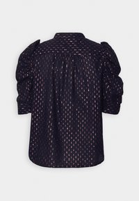 Blouse marine avec motif à pois dorés métallisés, dos froncé et manches bouffantes froncées se terminant au niveau du coude.
