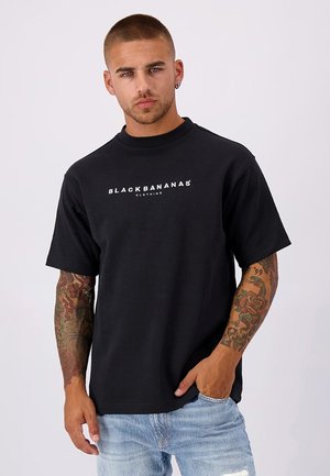 Zwarte t-shirt met ronde hals, voorzien van de tekst "BLACKBANANAS" in het wit over de borst. Gemaakt van katoen, eenvoudige ontwerp, korte mouwen.