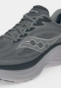 Γκρι παπούτσι τρεξίματος Saucony με αεριζόμενο διχτυωτό επάνω μέρος, επένδυση στη γλώσσα και μαξιλαρωμένη σόλα με λογότυπο στη πλευρά.