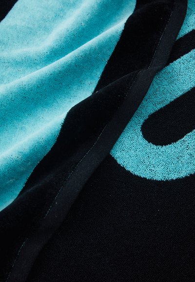 Turquoise and black towel with contrasting colors, soft texture, and a prominent graphic design element in light blue. Edges are stitched.