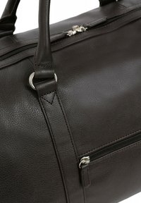 Borsa da viaggio in pelle marrone con superficie testurizzata, hardware argentato, doppi manici e una tasca con zip sul lato per ulteriore spazio di archiviazione.